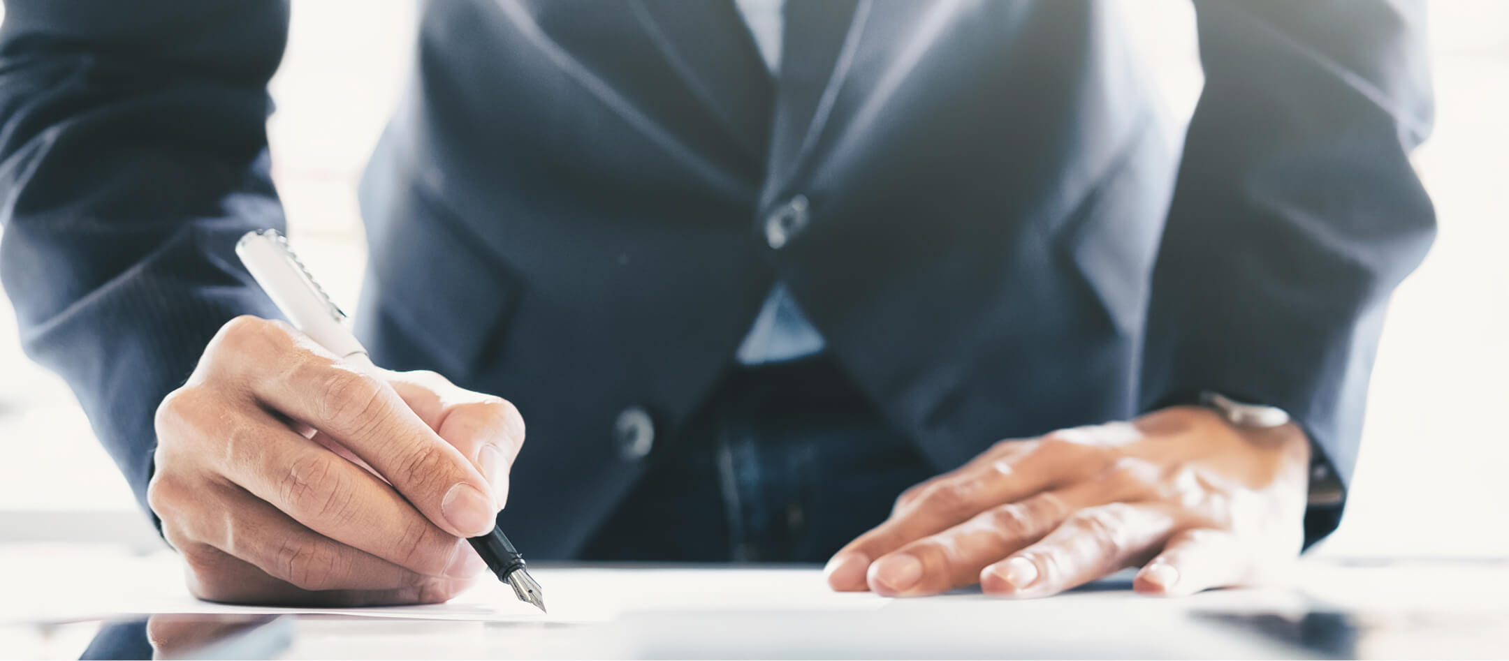 Geschäftsmann unterschreibt Vertrag – Symbol für Beratung und Strategieentwicklung